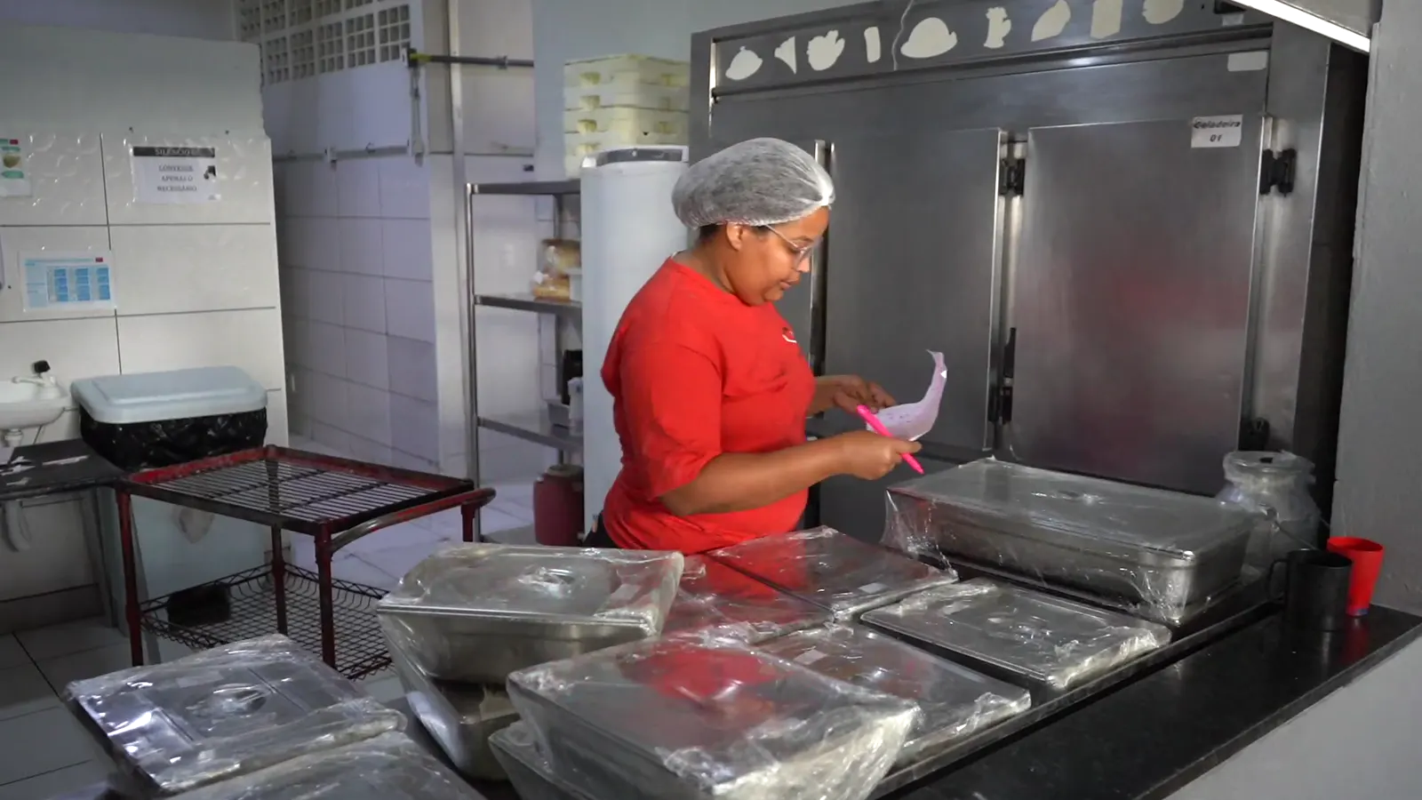 Montagem de quentinhas em embalagens de alumínio na cozinha da Gran Vitória